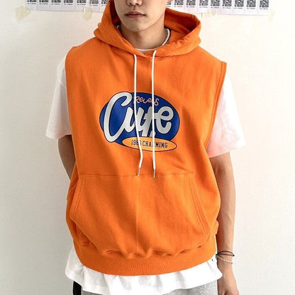 Model wearing coordinated shirt and sleeveless orange hoodie with English lettering. 