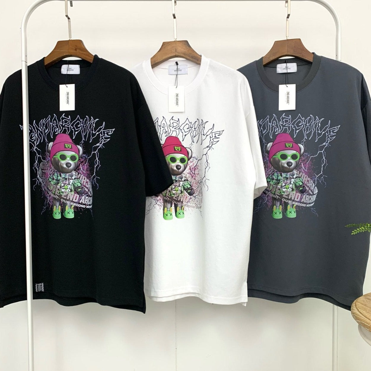 three cool graphic hip hop style t shirts hanging on a rack. 