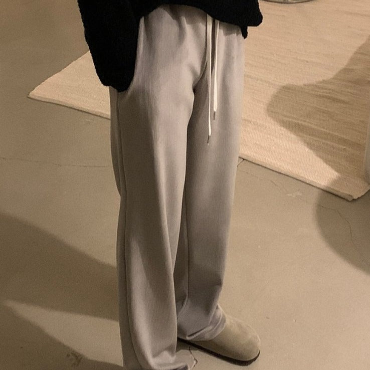 Right side view of gray winter pants worn by model standing in a room. 