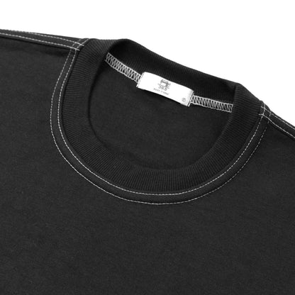 Close up of double stitched collared black shirt with brand tag.  