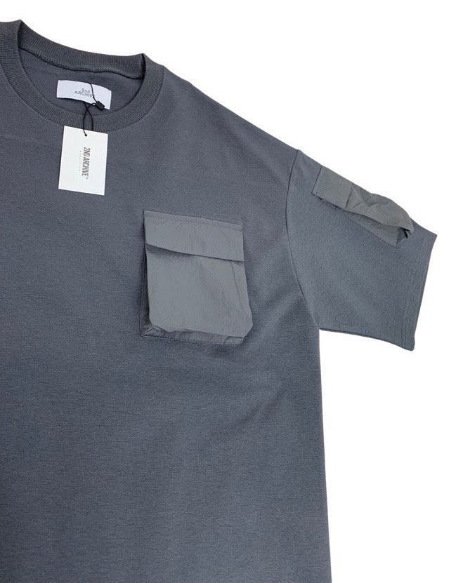 Close up of t-shirt with small pockets on chest and arm. 