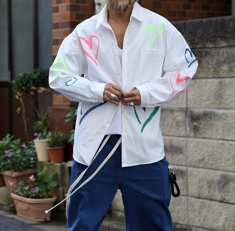 Korean model wearing white heart graphic button long sleeve shirt standing in the street. 