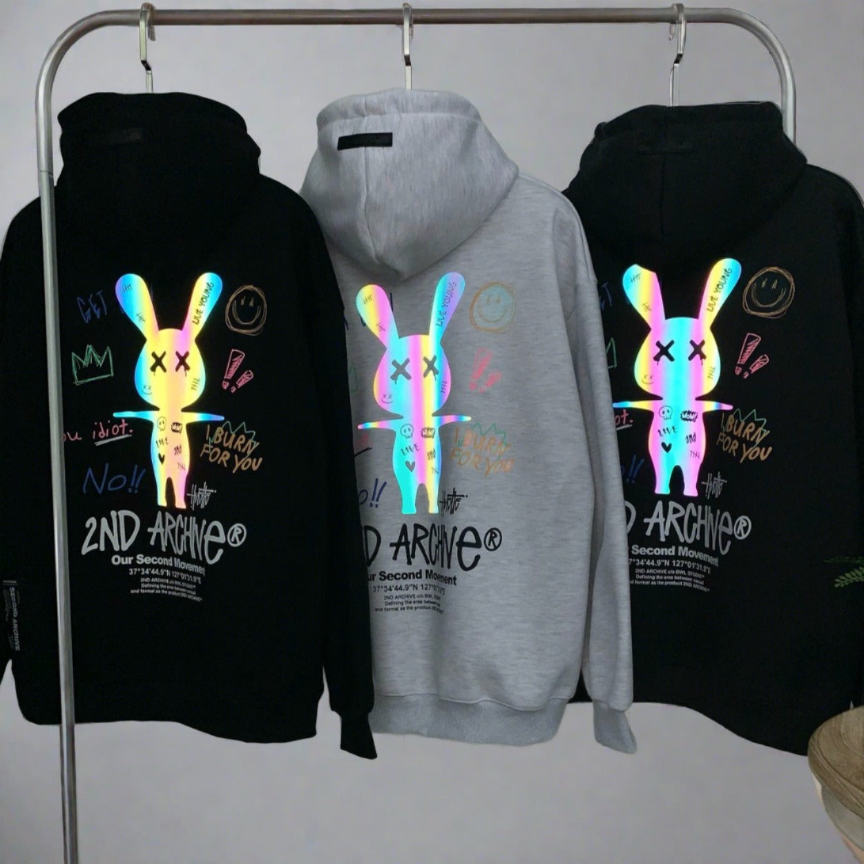 3 hoodie sweaters hanging on rack with cool graphic of graffiti style rabbit. 