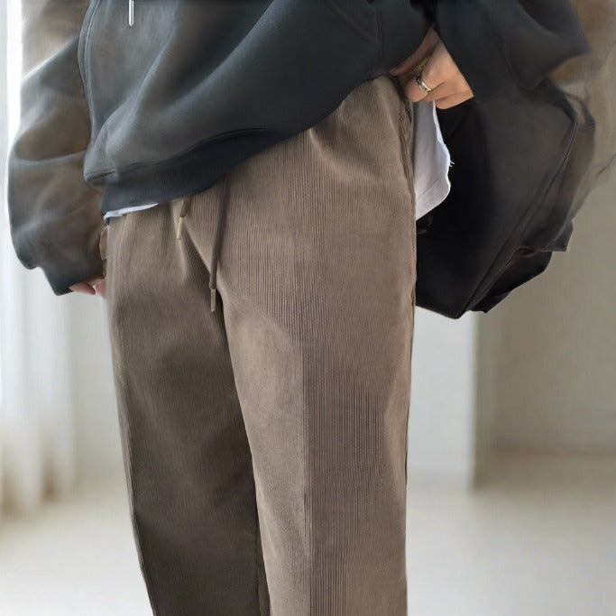 Close up view of brown corduroy pants worn by model.  