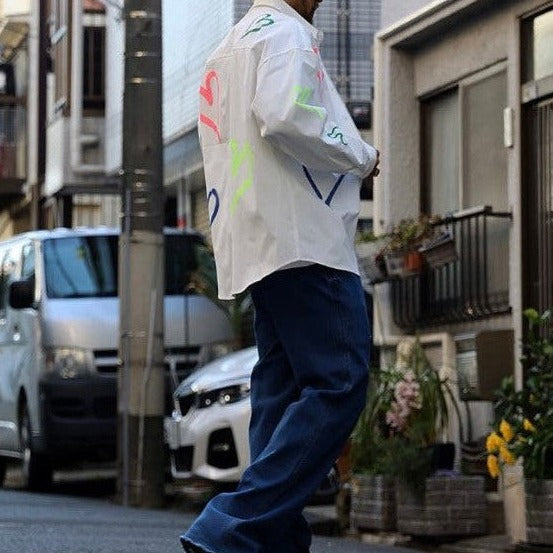 Model wearing Korean street fashion long sleeve shirt with colorful heart graphics. 