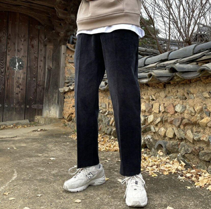 Slim fit Korean made pants worn by a model standing outside. 