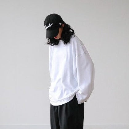 Korean model wearing a white unisex long sleeve shirt with an oversized design. 