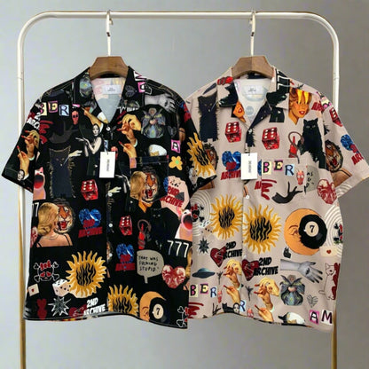 Two front facing pop art short sleeve shirts hanging on a rack. 