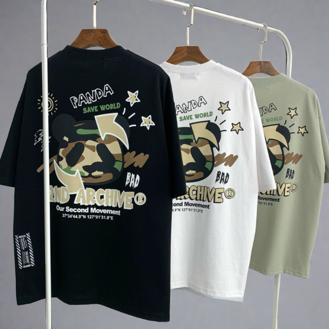 3 graphic t-shirts hanging on rack with logo an d panda bear graphic. 